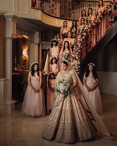 a bride and her bridal party posing for a photo in front of the staircase