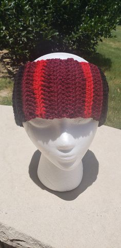 a white mannequin head wearing a red and black knitted hat