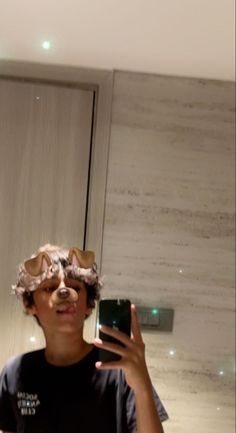 a person taking a selfie in front of a mirror with a cat mask on