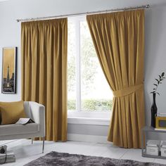 a living room filled with furniture and yellow curtains