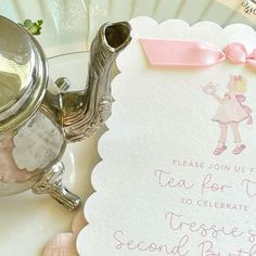 a tea pot with a pink bow on it next to a card that reads, please join us for tea for you to celebrate the second birthday