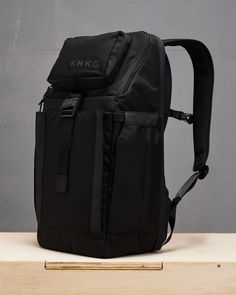 a black backpack sitting on top of a wooden table