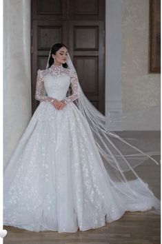 a woman in a white wedding dress and veil standing next to a door with her hands on her hips