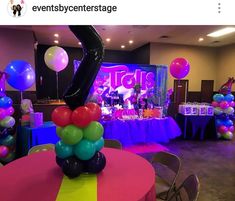 balloons and streamers are on the tables at an event