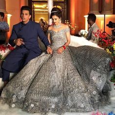 the man and woman are posing for a photo in their wedding gowns, with flowers all around them