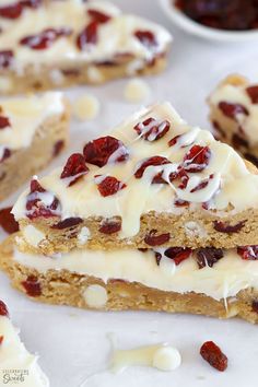 several pieces of cake with white frosting and cranberries