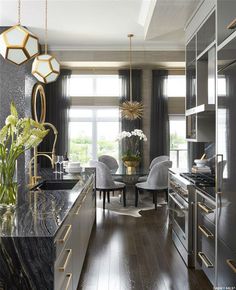 an elegant kitchen with marble counter tops and stainless steel appliances, along with gold accents