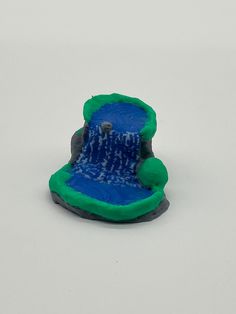 a blue and green toy boat floating on top of water