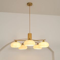 a chandelier with five lights hanging from it's sides in a room