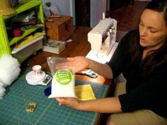 a woman sitting at a table with a bottle of milk in front of her and a sewing machine behind her