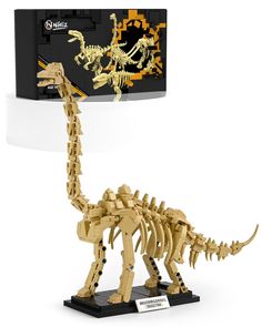 a toy dinosaur that is made out of legos and has a box behind it