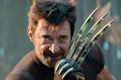 the wolverine man is holding up his claws