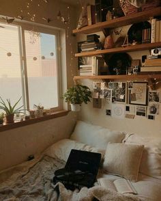 a bed room with a laptop on top of it and pictures hanging above the bed