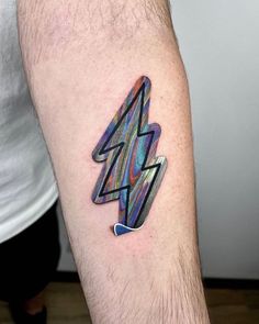 a man's arm with a colorful lightning tattoo on it