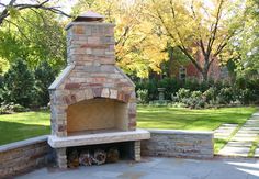 an outdoor fireplace in the middle of a yard