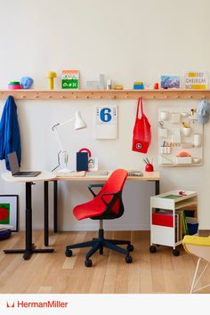 a desk with a red chair next to it