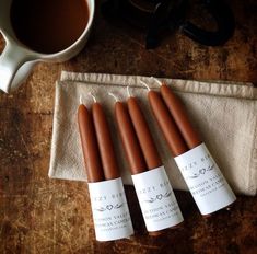 four candles sitting on top of a napkin next to a cup of coffee