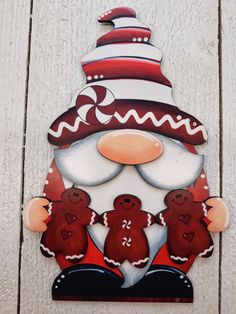 a santa clause with two gingerbreads on it's face is hanging from the side of a building