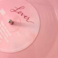 a pink record with the word love written on it's side and a small metal ball in the middle