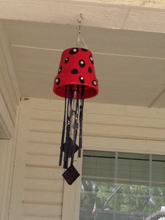 a red and black clock hanging from the side of a house