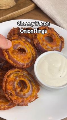 someone is picking up some onion rings on a plate