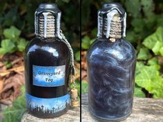 two bottles are sitting on a wooden table with plants in the background and one is empty