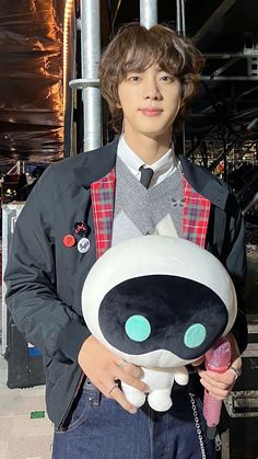 a young man holding a stuffed animal in his hands