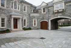 a large stone building with two brown doors and windows on each side of the entrance