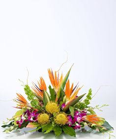 a bunch of flowers that are sitting on a table with white background in front of it