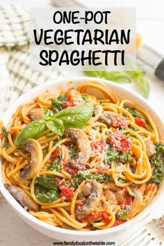 one pot vegetarian spaghetti with spinach, mushrooms and tomato sauce in a white bowl