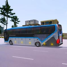 a blue and white bus driving down a street next to a tall building on top of a hill