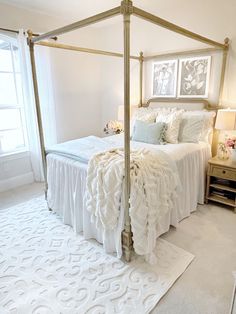 a white bed sitting in a bedroom next to a window