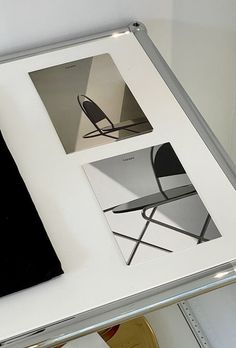 a white table topped with pictures and a black chair