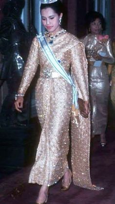 an old photo of a woman in a gold dress and tiara walking down the street