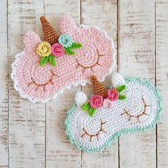 two crocheted unicorn coasters with flowers on them