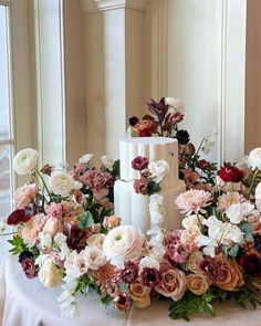 a wedding cake surrounded by flowers on a table