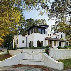 a large white house surrounded by trees and grass