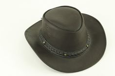 Our smooth leather cowboy hats are made of genuine cowhide leather. This beautifully handcrafted hat is made with fine craftsmanship and materials. Any scars, wrinkles or other subtle variations are characteristics of natural leather and do not affect its strength or quality. The unisex leather hat is embellished with brass conchos. The crown of the had also boasts a braided hat band. Use the strap for windy days or to keep it around your neck while traveling so you won't lose it. Perfect access Adjustable Leather Country Fedora, Country Style Wide Brim Hat With Leather Sweatband, Adjustable Rugged Leather Hat Bands, Country Style Leather Fedora, Western Brown Hat With Leather Sweatband, Western Leather Hat For Rodeo, Western Hat With Leather Sweatband For Western-themed Events, Rugged Adjustable Fedora For Western-themed Events, Country Style Hat With Leather Sweatband For Country Events