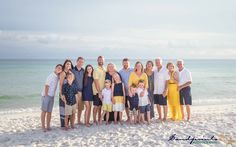 a group of people standing on top of a sandy beach next to the ocean in front of an ocean