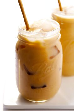 two mason jars filled with ice cream and topped with straws