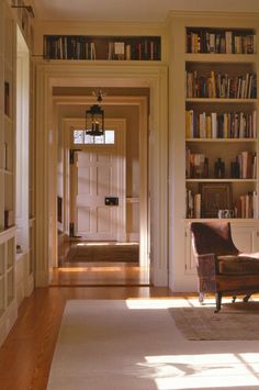 an empty room with a chair and bookshelves