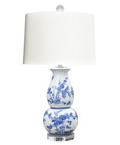 two blue and white vases with a lamp on top of one that is turned on