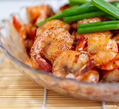 a glass bowl filled with shrimp and green beans