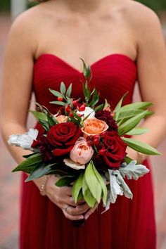 a woman in a red dress holding a bouquet of flowers