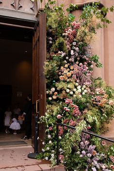 an entrance to a building with flowers growing on it