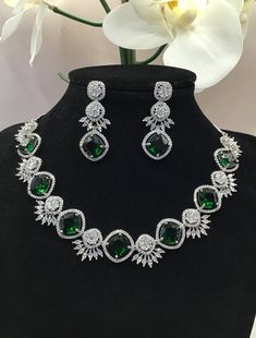 "Real looking AAA quality cubic zirconia white and Emerald stones necklace with an adjustable length, comes with earrings. Also available in Ruby Red. Beautiful design and craftsmanship gives it a rich look. Perfect for partywear. Dimension: 5\" x 5\" necklace and 1.75\" long earrings." Formal Bridal Necklace With Cubic Zirconia Stones, Cubic Zirconia Jewelry Sets With Stones, Cubic Zirconia Bridal Necklace With Stones As Gift, Cubic Zirconia Bridal Necklace For Party, Round Cubic Zirconia Bridal Necklace For Party, Party Necklaces With Hand Set Cubic Zirconia, Cubic Zirconia Bridal Necklace With Stones For Party, Party Bridal Necklace With Cubic Zirconia Stones, Necklace Ruby