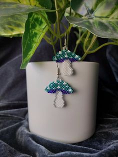 a pair of earrings hanging from a potted plant