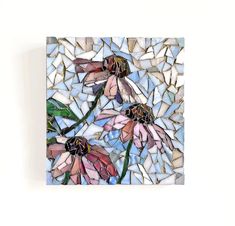 a mosaic tile wall hanging with flowers on it's side and one flower in the middle