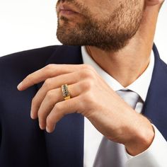 a man in a suit and tie wearing a ring