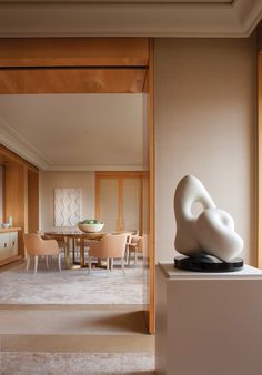 a white sculpture sitting on top of a table in front of a window next to a dining room